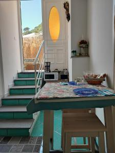 een keuken met een tafel en een trap met een raam bij Amalfi Small Wonder Tiny Town House in Amalfi