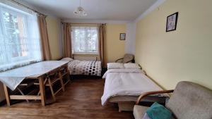 a room with two beds and a table in it at AGAWA NOCLEGI in Tarnów