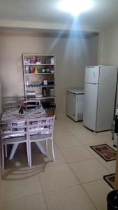 a kitchen with a white table and a refrigerator at Apê perto do Parque Euclides Dourado in Garanhuns