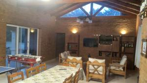sala de estar con mesas, sillas y TV en QUINTA LA ESTELA, en Pilar