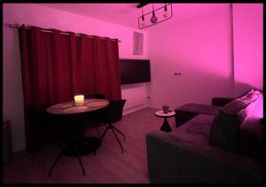 a living room with a couch and a table with a candle at Le Cocon in Saint-Quentin +2 photos