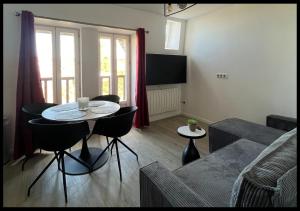 a living room with a table and chairs and a couch at Le Cocon in Saint-Quentin