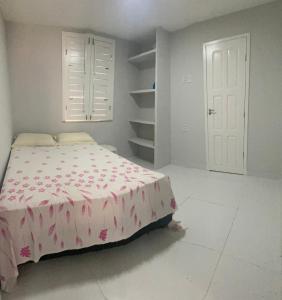 a bedroom with a bed with a pink blanket at Apartamento térreo no Morro Branco Marina II in Beberibe