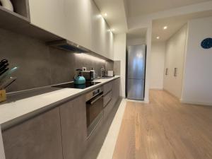 a kitchen with stainless steel appliances and wooden floors at Exceptional Belgrade Waterfront Apartment - Beograd na Vodi in Belgrade