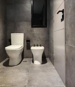 a bathroom with a toilet and a sink at AMSTERDAM DEPARTAMENTOS in Villa Carlos Paz