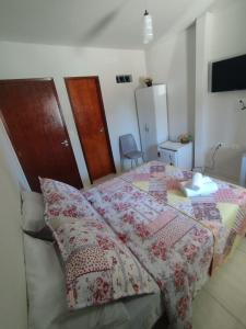 a bedroom with a bed with a quilt on it at Pousada Brumar in Maragogi