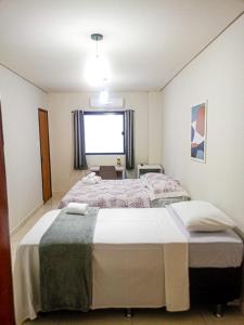 a bedroom with two beds and a large window at Pousada Brumar in Maragogi