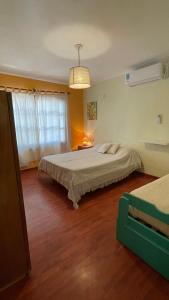 a bedroom with two beds and a chandelier at Ruca Epu in Las Grutas