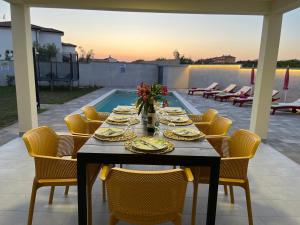 un tavolo con piatti di cibo su un patio di Villa Leandra a Vodnjan (Dignano)