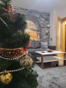 een kerstboom in een woonkamer met een bank bij Apartman S Pale in Pale