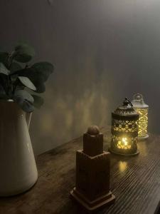 une table avec deux lanternes et un vase avec une plante dans l'établissement L’algéroise Home & Spa, à Ronchin