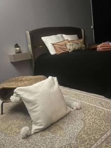 a bedroom with a bed with pillows on it at L’algéroise Home & Spa in Ronchin