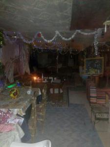 een woonkamer met een tafel, stoelen en verlichting bij Café Autor Dan et Eger Nouvelle Restaurant in Ouzoud