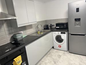 cocina con nevera y lavadora en Remarkable 3-Bed House in Basildon, en Basildon