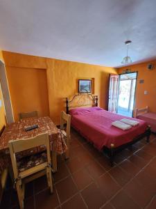 ein Schlafzimmer mit einem großen Bett und einem Tisch in der Unterkunft Complejo Mayu Inti Wayra - Mayu Sumaj in Villa Icho Cruz