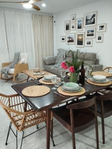 een woonkamer met een tafel met stoelen en een bank bij LA PONDEROSA BEACH in Sanlúcar de Barrameda