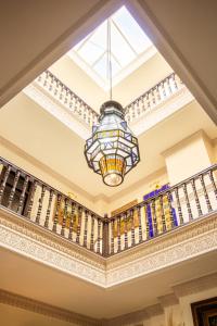 a chandelier hangs from the ceiling of a staircase at Hotel Palacio de Hemingway in Ronda