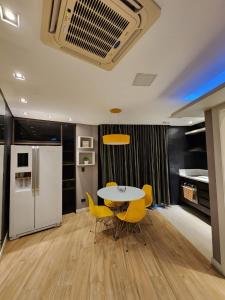 une salle à manger avec une table et des chaises jaunes dans l'établissement Studio no Hotel Bristol 500 - Bairro Batel, à Curitiba
