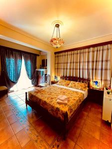 1 dormitorio con cama y lámpara de araña en Odysseas ART Villa, en Póros