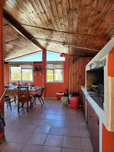 cocina con paredes de color naranja y techo de madera en Complejo Mayu Inti Wayra - Mayu Sumaj, en Villa Icho Cruz