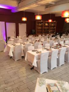 un salón de banquetes con mesas blancas y sillas blancas en Auberge de l'Etoile, en Thoiry