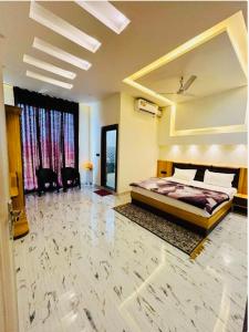 duża sypialnia z łóżkiem i dużym oknem w obiekcie Lotus Palm Retreat - Full Villa (By A.P. Villa's) w mieście Ujjain