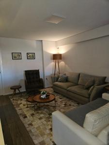 a living room with a couch and a table at Apartamento Alto Padrão Uruguaiana in Uruguaiana