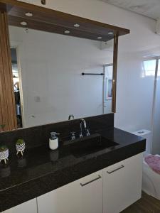 a bathroom with a sink and a large mirror at Apartamento Alto Padrão Uruguaiana in Uruguaiana