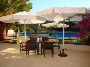 a table and chairs under white umbrellas on a patio at Monte Vardia in Chania Town