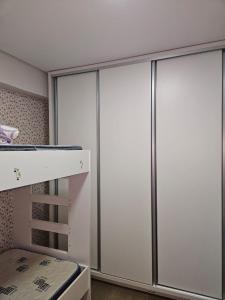 a closet with sliding doors in a bedroom at Apartamento Alto Padrão Uruguaiana in Uruguaiana