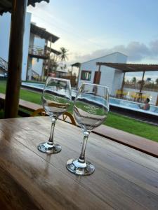 Kanto do Chico في إيكاري: كأسين من النبيذ يجلسون على طاولة خشبية