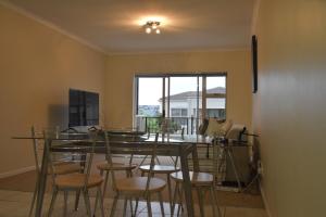 een eetkamer met een tafel en stoelen en een raam bij 303 Formosa in Kaapstad