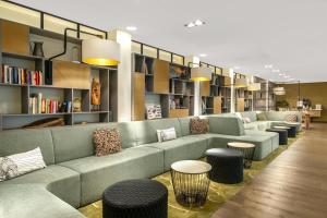 a library with couches and tables and bookshelves at Element Amsterdam in Amsterdam