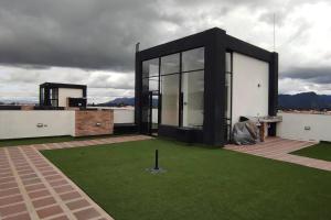 a black and white house with a green lawn at Aparment comfort deluxe cajica in Cajicá