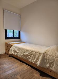 1 dormitorio con cama y ventana en AMSTERDAM DEPARTAMENTOS en Villa Carlos Paz