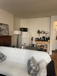 a living room with a white couch and a kitchen at Cozy place in midtown NYC in New York