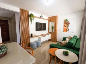 a living room with a green couch and a table at JPN18 - Duplex em condomínio fechado próx. à praia in Natal