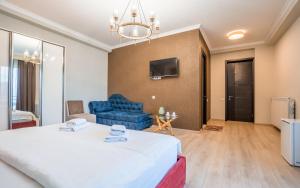 - un salon avec un grand lit et un canapé bleu dans l'établissement Rivendell Boutique By Umbrella, à Tbilissi