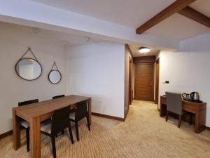亞霍里納的住宿－Apartman Queen Vučko，一间带木桌和椅子的用餐室