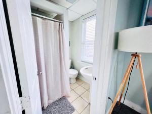 een badkamer met een toilet en een douchegordijn bij Entire Lovely 3 Bedroom, 2 Bathroom Apartment! 1 Block to the Beach and Boardwalk! in Wildwood