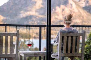 een vrouw op een stoel met een glas wijn bij The Bolthole in Coles Bay