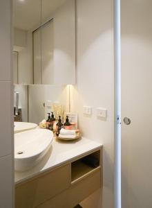 uma casa de banho com um lavatório branco e um espelho. em Walkerville Bliss em Adelaide