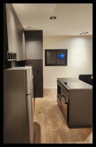 a kitchen with a stainless steel refrigerator and a sink at AMSTERDAM DEPARTAMENTOS in Villa Carlos Paz
