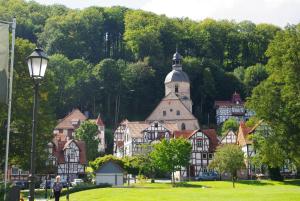 eine Gruppe von Häusern mit einer Kirche und einer Straßenbeleuchtung in der Unterkunft Ulrike's Pension am Kurpark in Bad Sooden-Allendorf