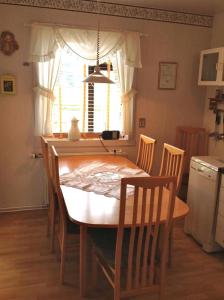 a dining room table and chairs in a kitchen with a window at Sólheimar Apartment in Húsavík