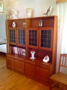 un centro de entretenimiento de madera con una estantería de libros en Sólheimar Apartment, en Húsavík