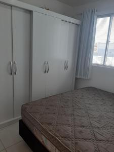 舊巴拉的住宿－Apartamento 2 quartos com Ar，一间卧室配有一张床、橱柜和窗户。