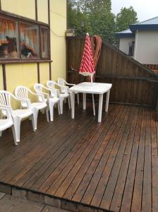 a patio with a table and chairs on a deck at Sólheimar Apartment in Húsavík