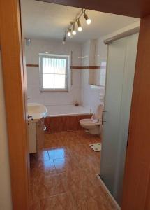 a bathroom with a tub and a toilet and a sink at 4 Zimmer Wohnung im 1. Stock in Traunreut