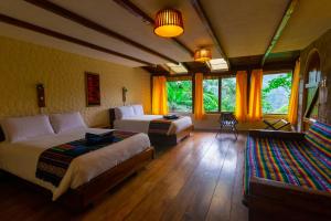 a bedroom with two beds and a large window at Bellavista Cloud Forest Lodge & Private Protected Area in Tandayapa